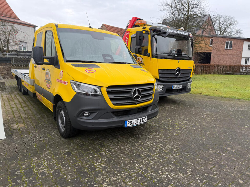 Gelbe Abschleppfahrzeuge Mercedes Transporter und LKW vom Abschleppdienst im Einsatz bereit für 24h Notdienst
